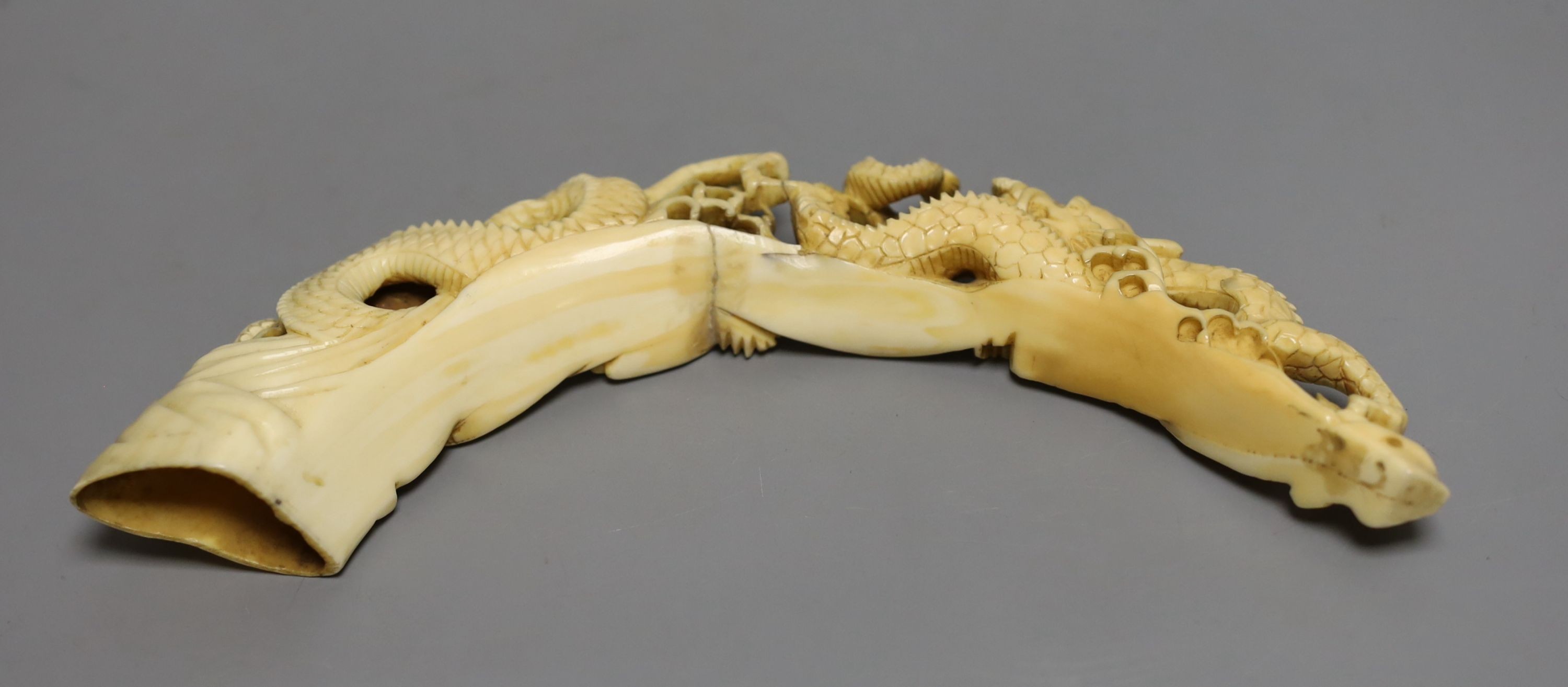 A Japanese boars tusk carving of two confronting dragons, Meiji period - 12cm high